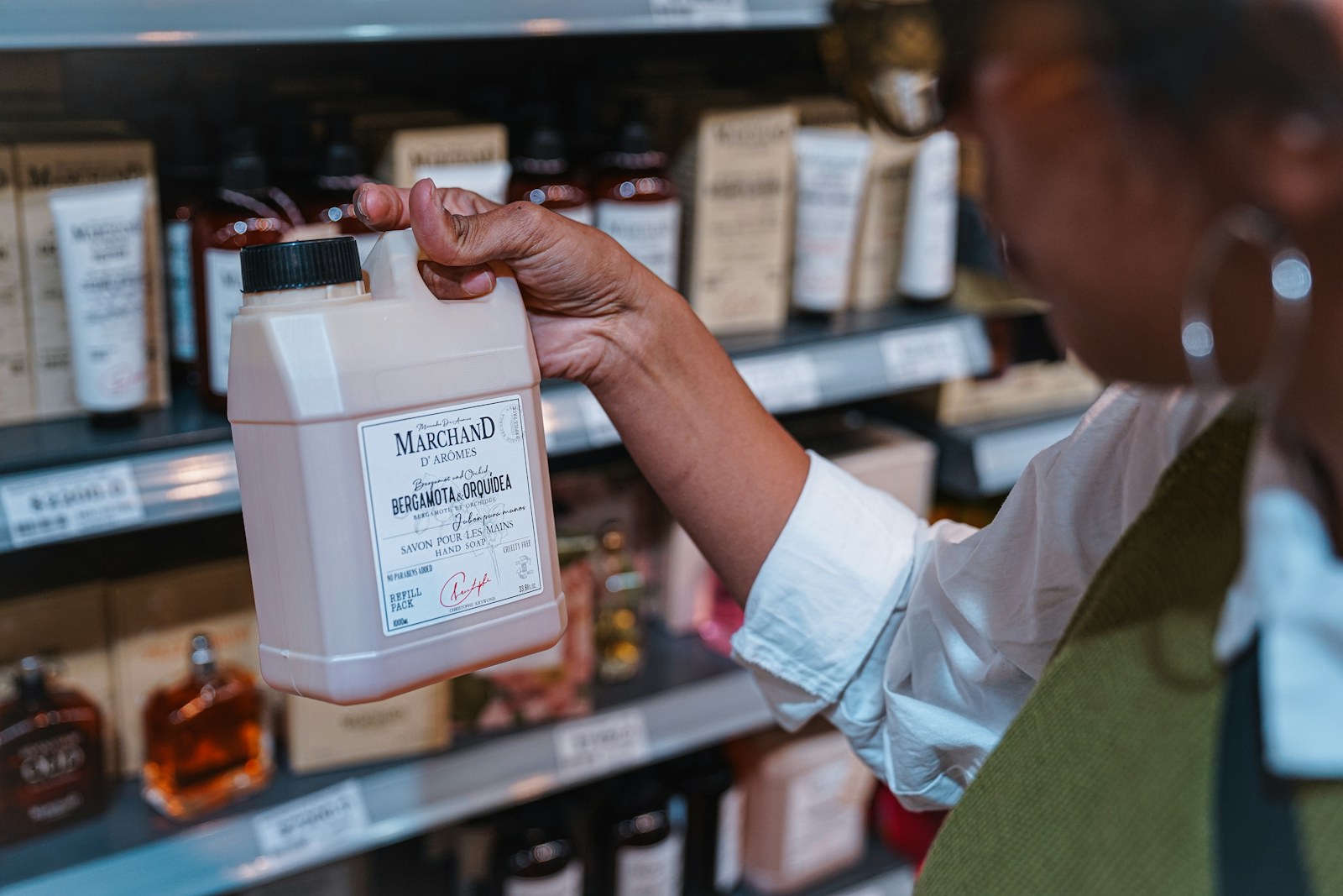 Une personne examine le flacon d’un produit cosmétique dans le rayon d’un magasin